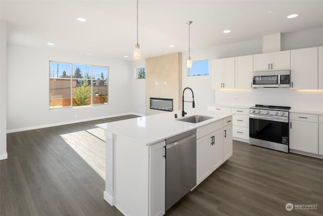 kitchen featuring dark wood-style floors, tasteful backsplash, appliances with stainless steel finishes, and a sink