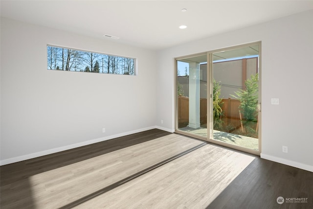 empty room featuring recessed lighting, visible vents, baseboards, and wood finished floors