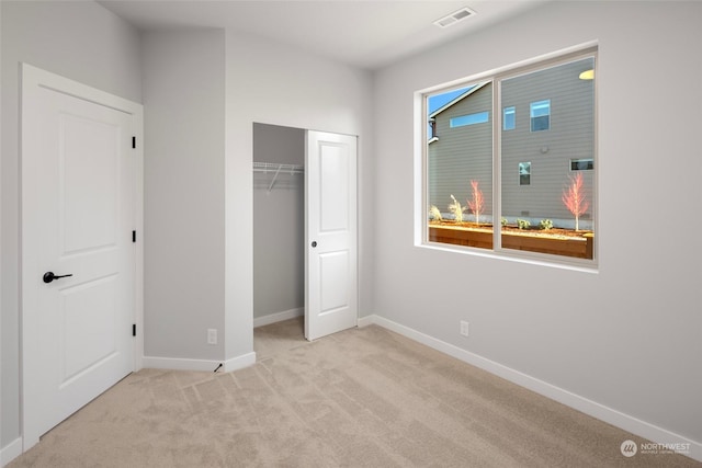 unfurnished bedroom featuring carpet, a closet, visible vents, and baseboards