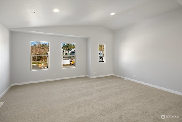 empty room with lofted ceiling, light carpet, baseboards, and recessed lighting