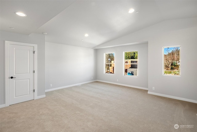 carpeted spare room with lofted ceiling, baseboards, and recessed lighting