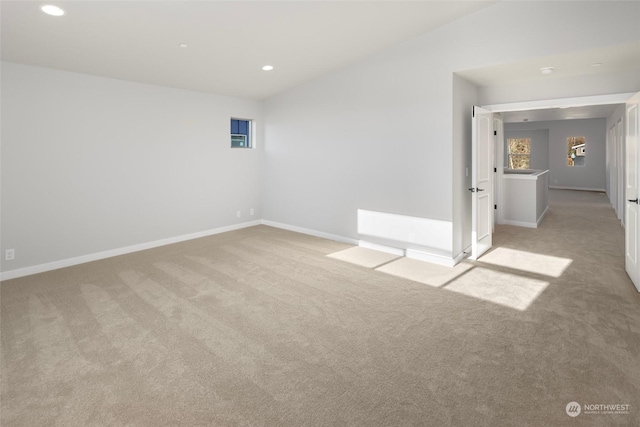 spare room featuring baseboards, recessed lighting, and light colored carpet