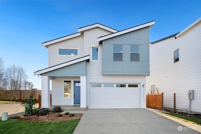 modern home with an attached garage, board and batten siding, fence, and concrete driveway