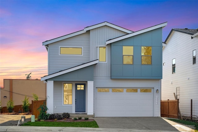 view of front of home with driveway, an attached garage, and fence