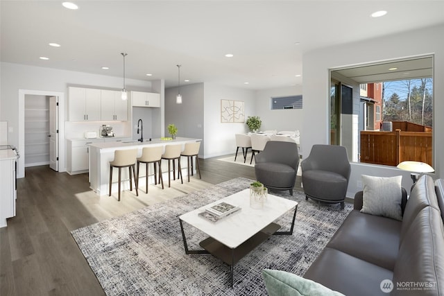 living room with recessed lighting, baseboards, and wood finished floors