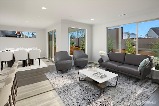 living room featuring plenty of natural light, recessed lighting, visible vents, and light wood-type flooring