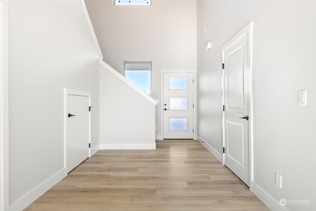 entrance foyer with light hardwood / wood-style flooring and a high ceiling