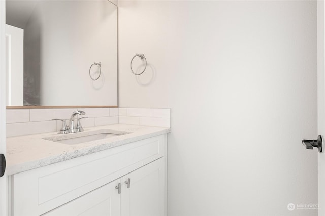 bathroom featuring vanity and decorative backsplash