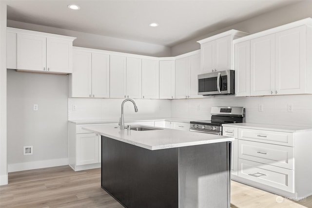 kitchen featuring appliances with stainless steel finishes, sink, a center island with sink, and white cabinets