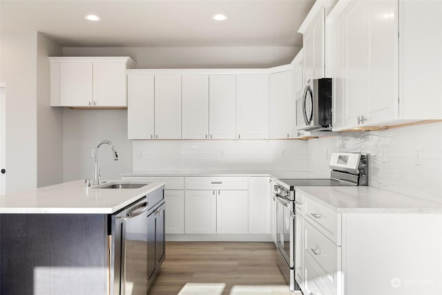 kitchen with sink, light hardwood / wood-style floors, white cabinets, and appliances with stainless steel finishes