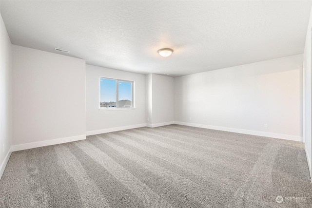 carpeted empty room featuring a textured ceiling