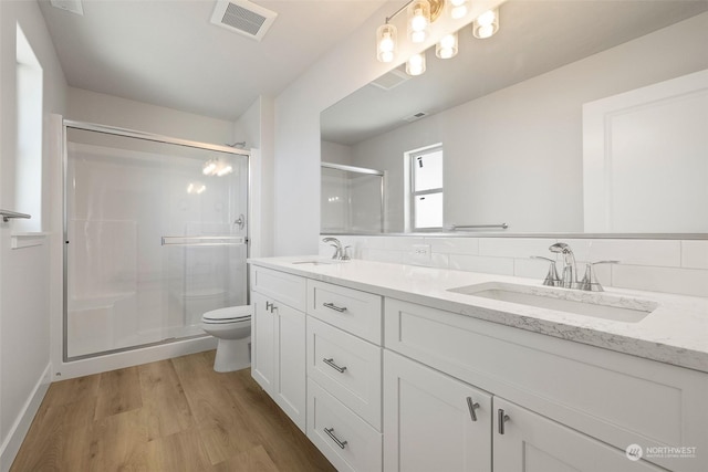 bathroom with vanity, hardwood / wood-style flooring, a shower with door, and toilet