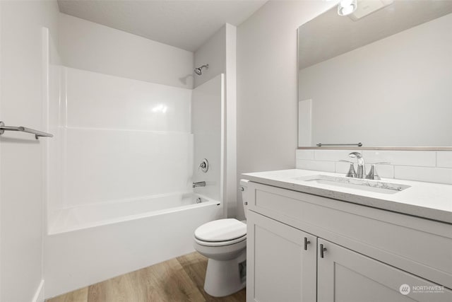 full bathroom with hardwood / wood-style flooring, vanity, toilet, and shower / bathing tub combination