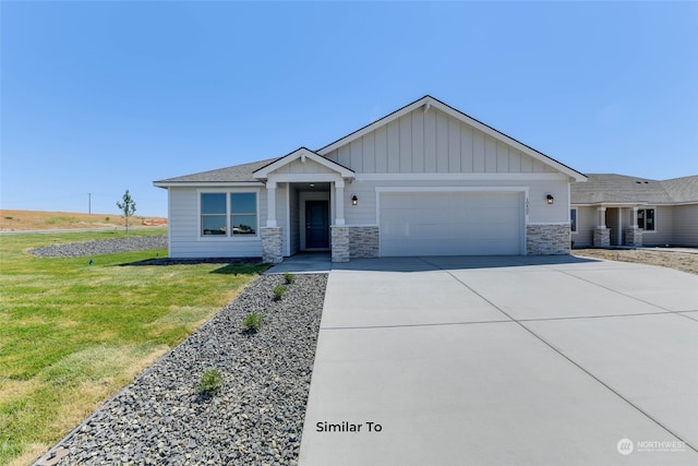 view of front of home featuring driveway, a front lawn, stone siding, board and batten siding, and an attached garage