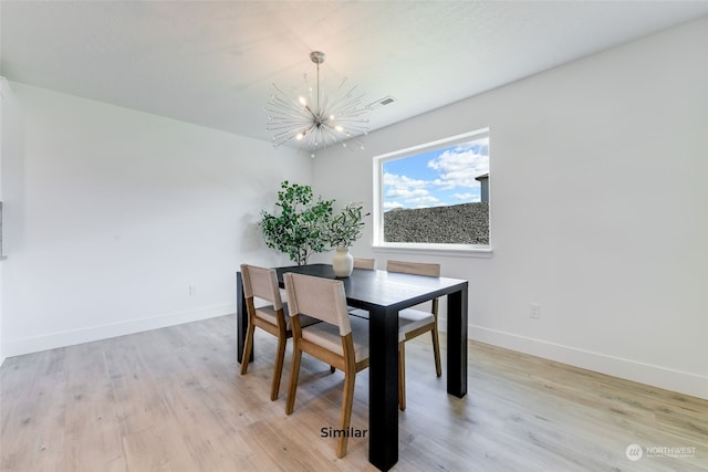 dining room featuring light hardwood / wood-style floors and a notable chandelier