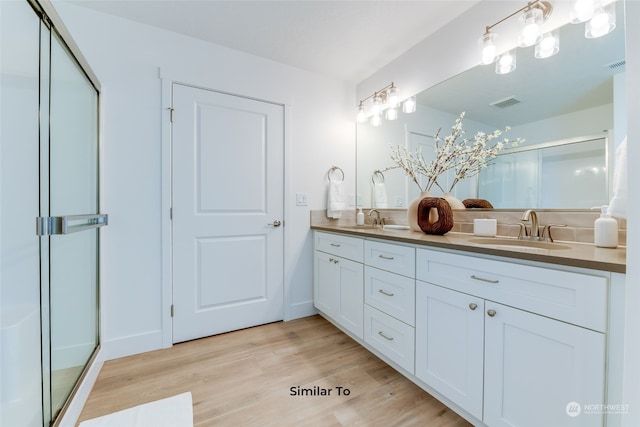 bathroom featuring walk in shower, hardwood / wood-style flooring, and vanity