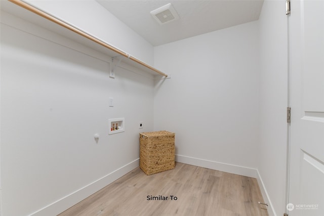 clothes washing area with light wood-type flooring, hookup for a washing machine, hookup for an electric dryer, and gas dryer hookup