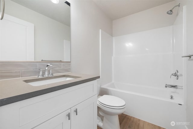 full bathroom featuring bathing tub / shower combination, wood-type flooring, vanity, and toilet