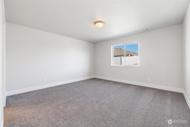 spare room featuring a textured ceiling and carpet flooring