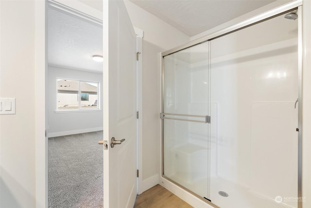 bathroom with walk in shower and a textured ceiling