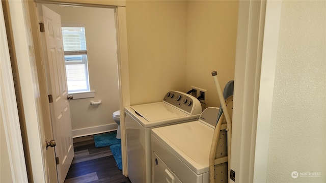 clothes washing area with dark wood-type flooring and washer and clothes dryer