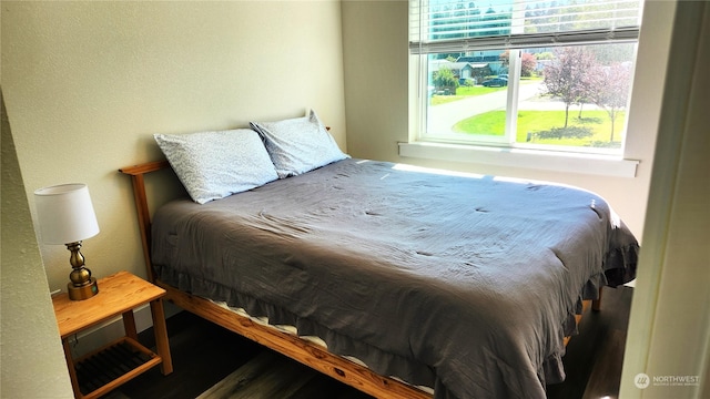 bedroom with multiple windows and hardwood / wood-style floors