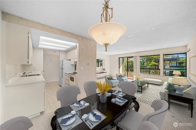 tiled dining space with a textured ceiling and sink