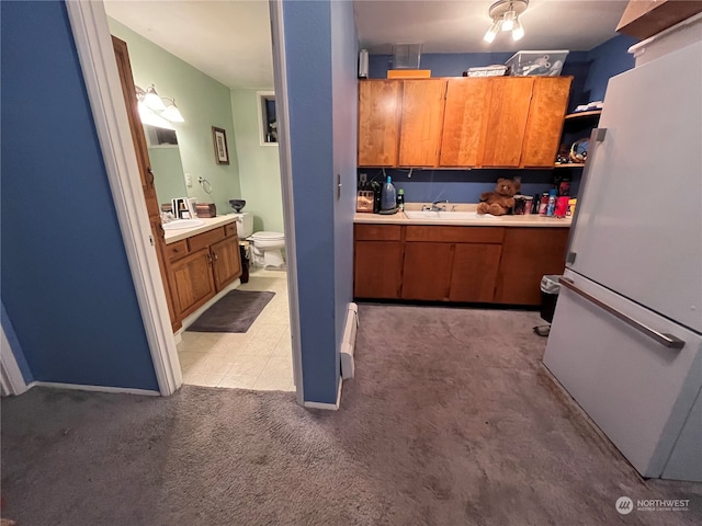 interior space with white fridge, a baseboard radiator, and light carpet