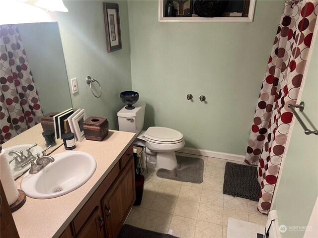 bathroom with a shower with shower curtain, vanity, toilet, and tile patterned floors