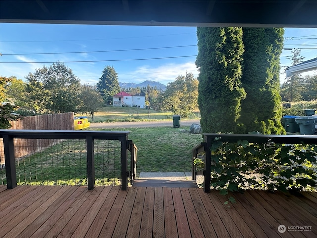 wooden terrace featuring a yard and a mountain view