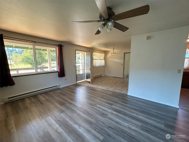 unfurnished living room featuring a textured ceiling, baseboard heating, wood-type flooring, and ceiling fan