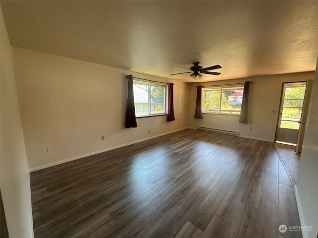 spare room with dark wood-type flooring, a baseboard heating unit, ceiling fan, and a textured ceiling