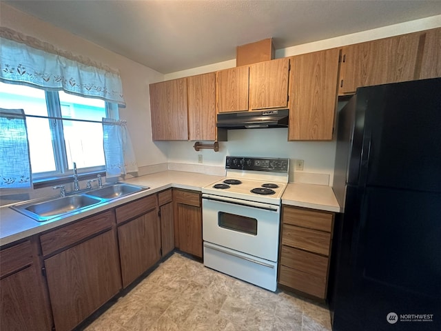 kitchen featuring electric range, sink, and black fridge