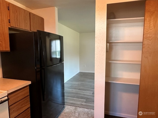 kitchen with black refrigerator and light hardwood / wood-style floors