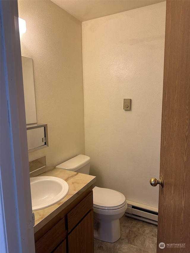 bathroom featuring tile patterned floors, a baseboard heating unit, toilet, and vanity