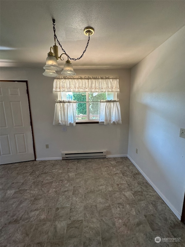 unfurnished room featuring a baseboard heating unit and a textured ceiling