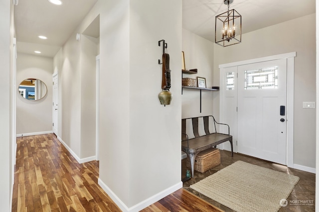 foyer featuring dark wood-type flooring and a chandelier