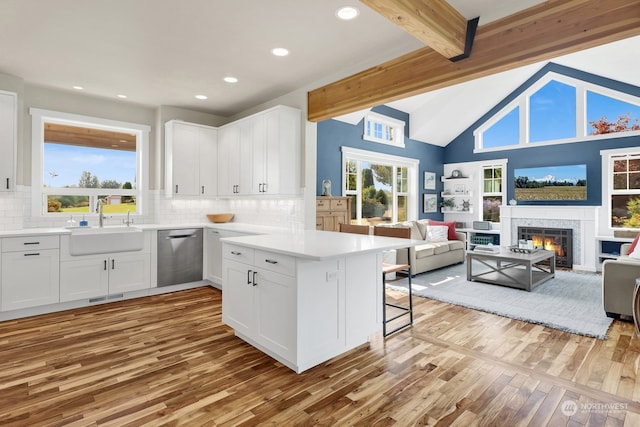 kitchen with dishwasher, light wood-type flooring, white cabinetry, sink, and tasteful backsplash