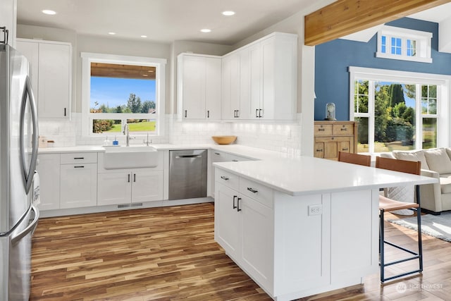 kitchen featuring plenty of natural light, appliances with stainless steel finishes, and white cabinetry