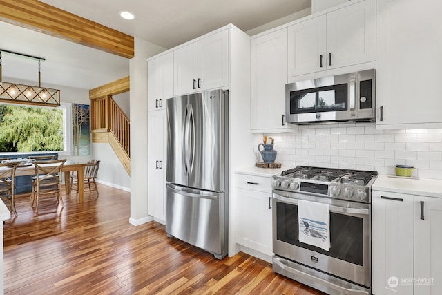 kitchen featuring beamed ceiling, backsplash, wood-type flooring, stainless steel appliances, and white cabinetry