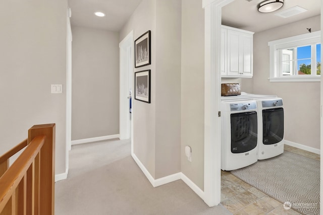 laundry room featuring cabinets, washing machine and clothes dryer, and light carpet