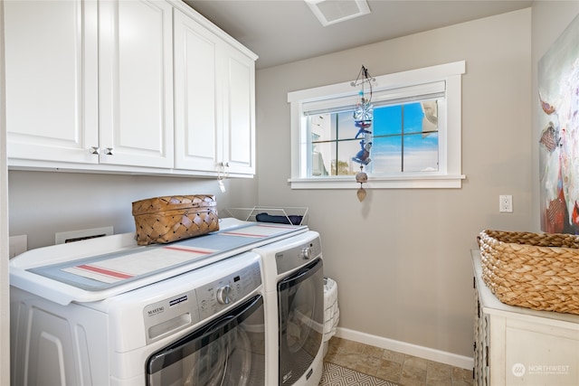 laundry room featuring cabinets and washing machine and dryer