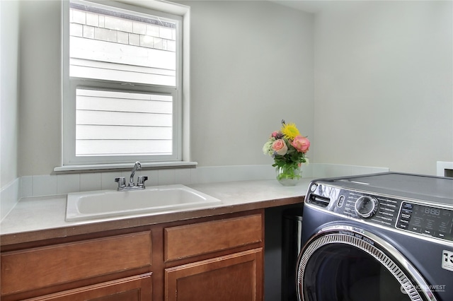 washroom with washer / dryer, cabinets, and sink