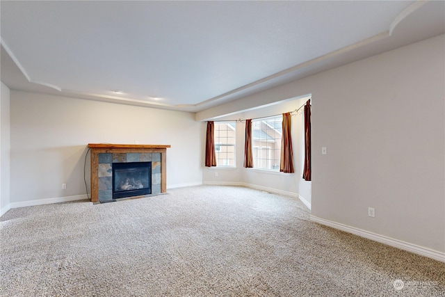 unfurnished living room featuring carpet flooring and a tiled fireplace