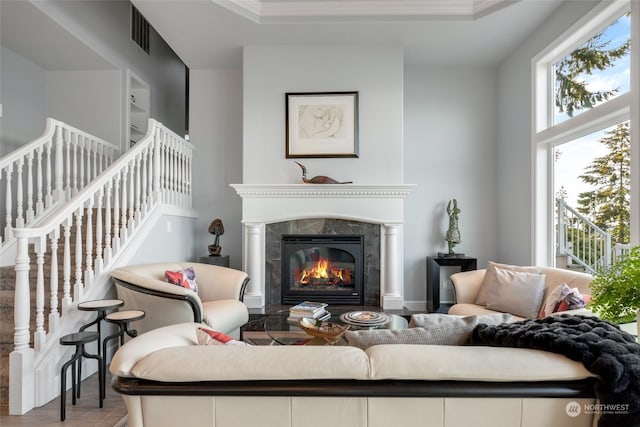 living area with stairs, a fireplace, wood finished floors, and visible vents