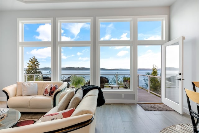 living room with a water view and light hardwood / wood-style floors