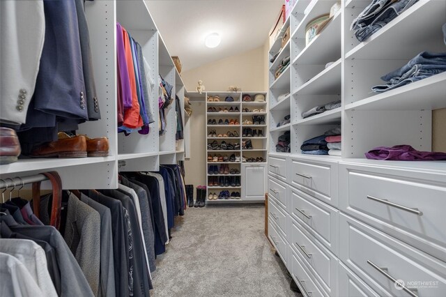 spacious closet featuring lofted ceiling and light colored carpet