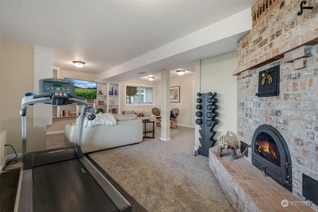 exercise room featuring carpet and a fireplace