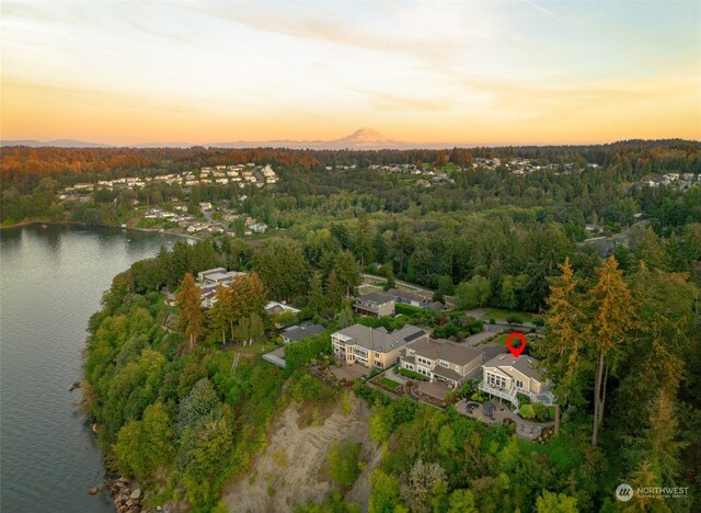 aerial view at dusk featuring a water view