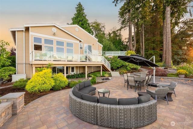 rear view of property with outdoor dining space, a patio area, stairway, and an outdoor hangout area